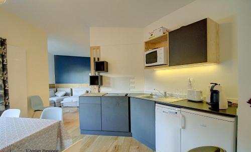 cocina con armarios azules y sala de estar. en Appartement familial - La Tania en La Tania