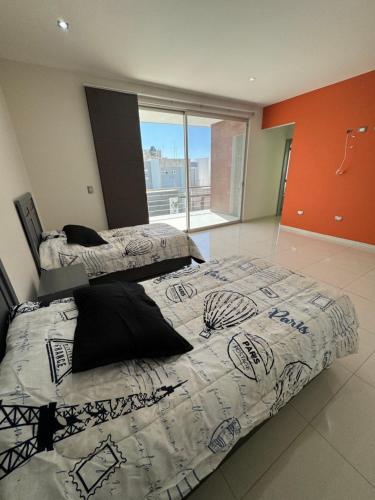 a bedroom with two beds and a large window at CASA MEBA in Aguascalientes