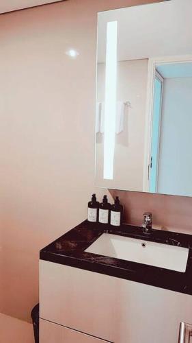 a bathroom with a sink and a mirror at 京都Kyoto Home 2BR - 53 Sqm at Downtown Semarang in Semarang