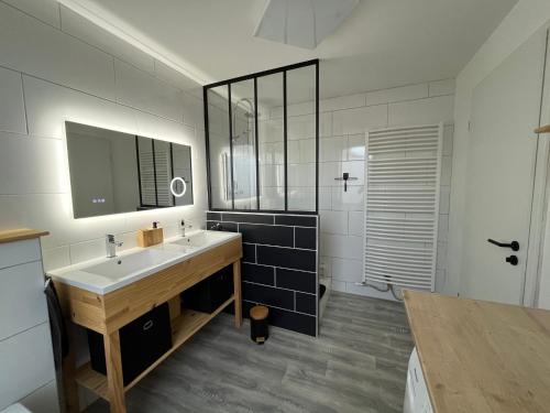 La salle de bains est pourvue d'un lavabo et d'un miroir. dans l'établissement Appartement St Eloi 75m², à Saint-Dié-des-Vosges
