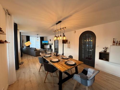 a dining room and living room with a table and chairs at Appartement St Eloi 75m² in Saint Die