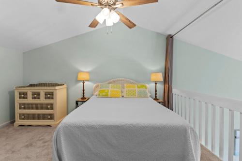 um quarto com uma cama e uma ventoinha de tecto em OceanScape- Beach, Pool, and Sun near the heart of Surf City! em Surf City