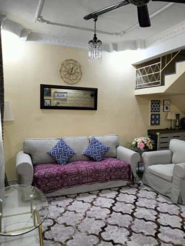 a living room with a couch and a chandelier at Homestay Cikgu in Pasir Gudang