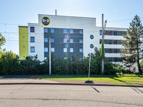 un edificio con una señal delante de él en B&B Hotel Freiburg-Süd, en Freiburg im Breisgau