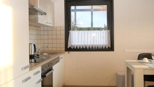 メシェデにあるFerienhaus Henneseeblick - Lake - View - Terrace - Hils - Wood - WIFIの窓とシンク付きのキッチンが備わります。