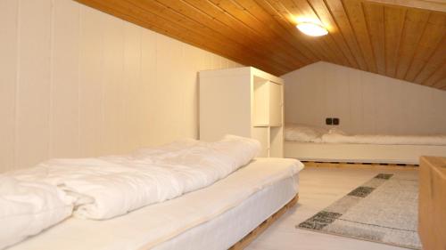 メシェデにあるFerienhaus Henneseeblick - Lake - View - Terrace - Hils - Wood - WIFIの木製の天井の客室で、ベッド2台が備わります。