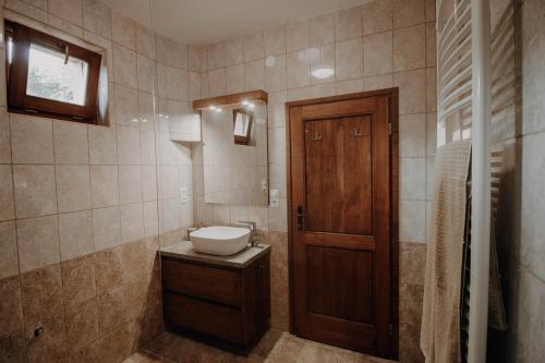 baño con lavabo y puerta de madera en Molnár Apartment, 