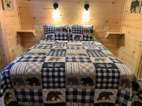 1 dormitorio con 1 cama con edredón de oso negro en Beaver Dam Mountain Cabins, en Travelers Rest