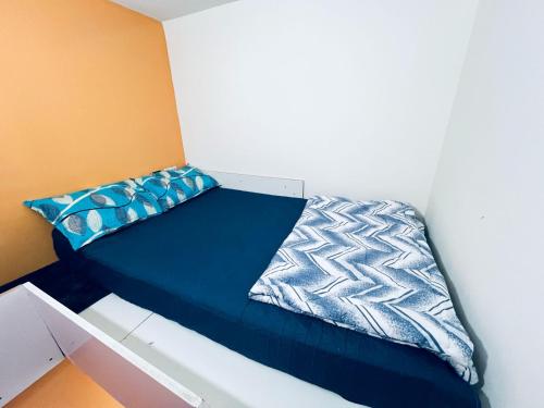 a bed with a blue comforter in a room at Moon Backpackers Burjman Exit 2, Family Partitions, Loft partitions, in Dubai
