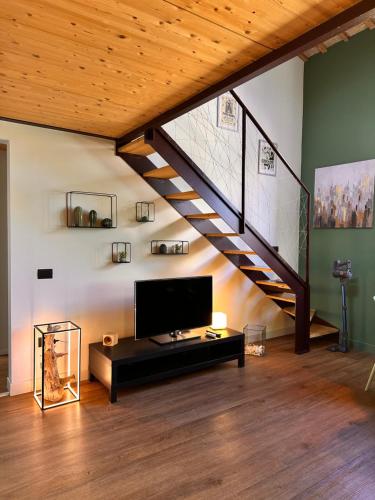 ein Wohnzimmer mit einer Treppe und einem TV in der Unterkunft La Casetta di Elena in Pesaro