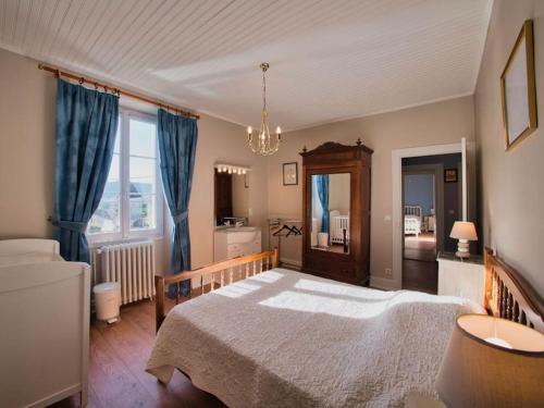 a bedroom with a large bed and a chandelier at Maison du Pont de la Roussie in CazoulÃ¨s