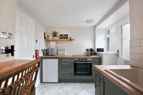 a kitchen with a sink and a stove top oven at Cosy Cottage, Central Ludlow, Free Parking, Boutique Hotel Style in Ludlow