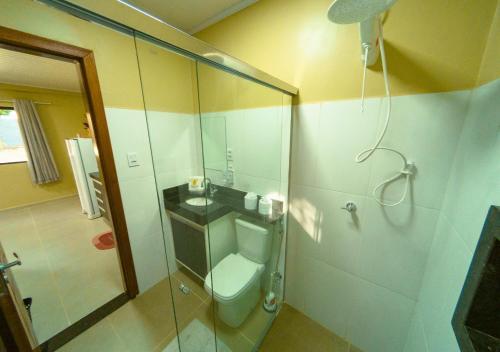 a bathroom with a toilet and a glass shower at Mango View Apartamento in Boa Vista