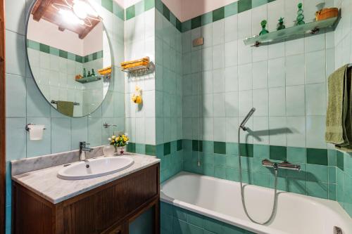 La salle de bains est pourvue d'une baignoire, d'un lavabo et d'un miroir. dans l'établissement Podere Torre degli Ulivi, à Palaia