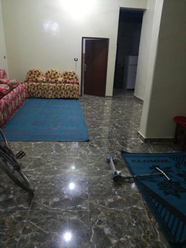 uma sala de estar com um sofá e tapetes azuis no chão em Small apartment in Egypt luxor West Bank without Home Home furnishings em ‘Ezbet Abu Ḥabashi