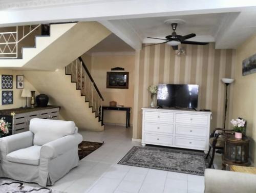 a living room with a ceiling fan and a tv at Homestay Cikgu-formuslimonly in Pasir Gudang