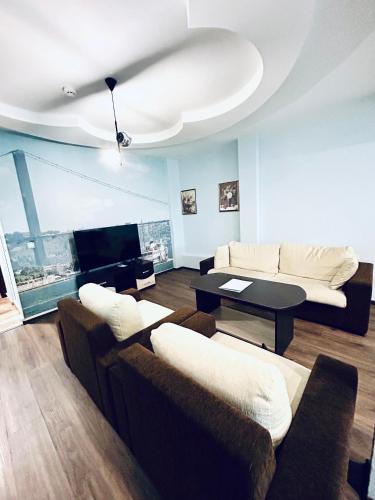 a living room with two couches and a table at Meatsa Hotel in Kŭrdzhali