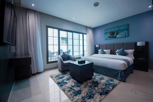 a bedroom with a king sized bed and a couch at فنـــــــــدق ايليفــــــــــــار Elevar Hotel in Al Khobar