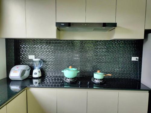 a kitchen counter with two pots on a stove at Hana Villa Hatyai in Suen Phra