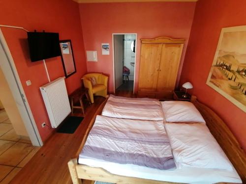 a bedroom with a bed in a room with orange walls at Gästehaus Burg Molbach in Kreuzau