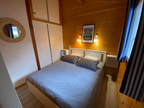 BiasにあるChalet 6 Personnes au calme dans les landes-Mimizanの木製の部屋にベッド1台が備わるベッドルーム1室があります。