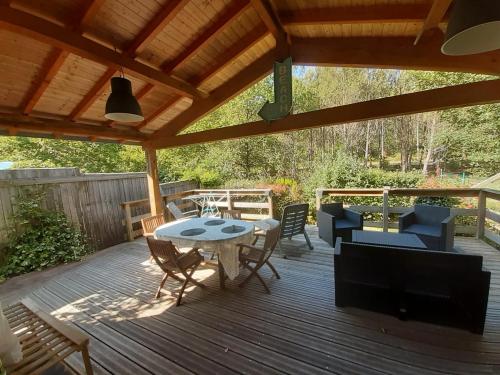 a patio with a table and chairs on a deck at Chalet 6 Personnes au calme dans les landes-Mimizan in Bias