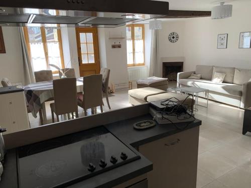 eine Küche und ein Wohnzimmer mit einem Tisch und einem Sofa in der Unterkunft Gite André De Vignory in Vignory