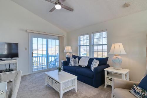 a living room with a blue couch and a tv at Comfort and Sun at Tranquility Cay in North Topsail Beach