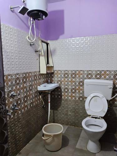 y baño con aseo y lavamanos. en Hotel Sarvapriya, en Chopan