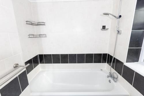 y baño con bañera y lavamanos. en Comfy 2 Bedroom House for 4 en Strood