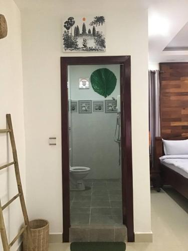 een badkamer met een bed en een toilet in een kamer bij Liza Boutique in Phumĭ Ta Phŭl