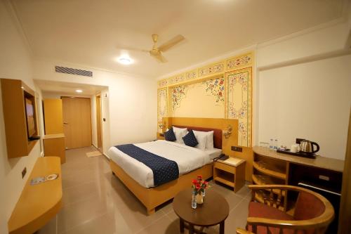 a hotel room with a bed and a table at Hotel Ganga Ratan in Agra