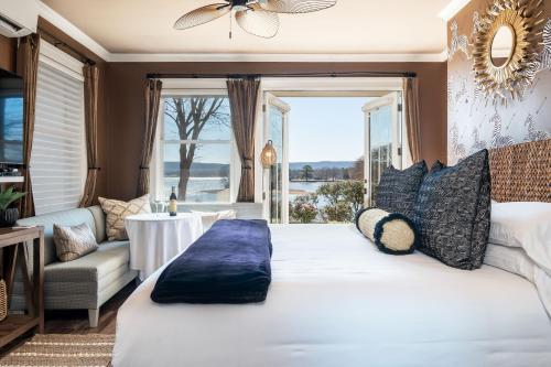 Un dormitorio con una gran cama blanca y una ventana en Lookout Point Lakeside Inn en Hot Springs