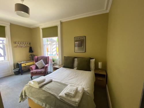 Grosvenor Place Guest House في تشيستر: غرفة نوم عليها سرير وفوط