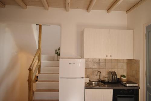 a kitchen with a white refrigerator and a staircase at NISOS Home Stay in Mýkonos City