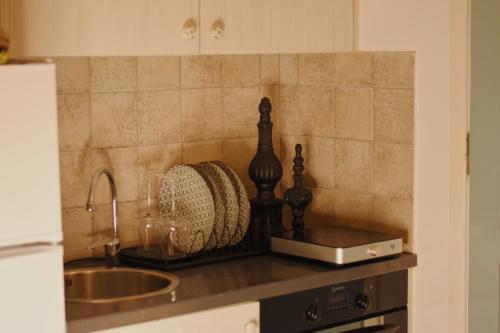 a kitchen counter with a sink and a basket at NISOS Home Stay in Mikonos