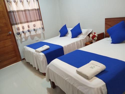 2 camas en una habitación de color azul y blanco en HOSPEDAJE SHELOMIT, en Nauta
