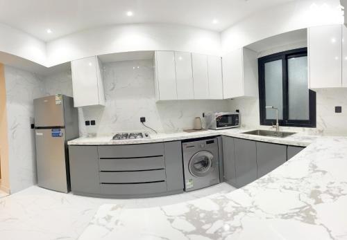 una cucina bianca con lavatrice al suo interno di شقق شهم المفروشه a Abha