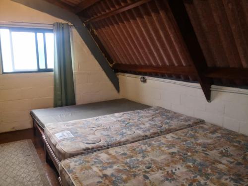 an empty bed in a room with a window at Sonidos de la Naturaleza!! in Los Altos de Cerro Azul
