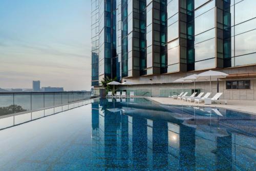 a swimming pool in front of a tall building at Sheraton Hong Kong Tung Chung Hotel in Hong Kong