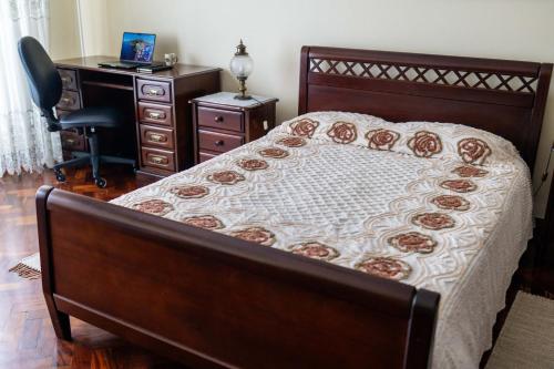 a bedroom with a bed and a desk with a computer at Casa da Tia Adília (AL) in Ponta Delgada