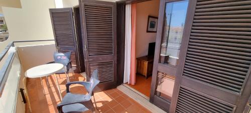 アルブフェイラにあるAlbufeira Jardim - Apartamentos Turísticosのテーブルと椅子、ドアが備わる部屋