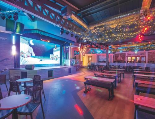 a restaurant with tables and chairs and a large screen at Haven holiday park Cleethorpes beach in Cleethorpes