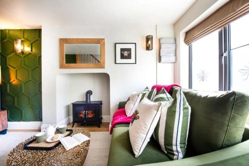 a living room with a green couch and a fireplace at The Hive, Central Ludlow, Free Parking, Boutique Hotel Style in Ludlow