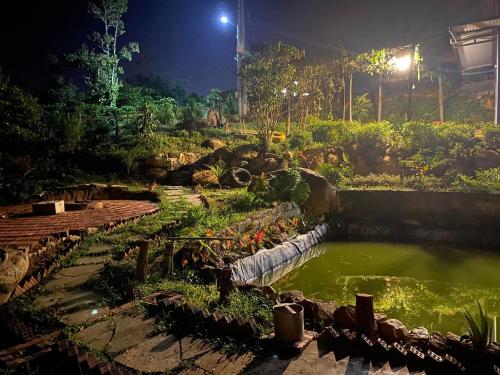 a pond in a garden at night at Lam Nguyên Charming House in Bao Loc
