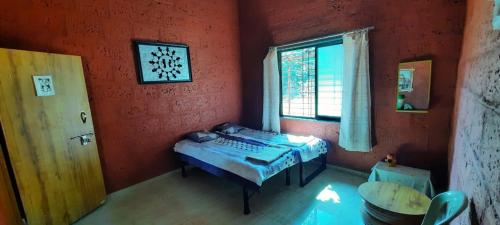 a room with a small bed in a room with a window at Om Gajanan Farms in Nerur