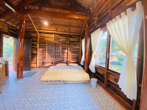 a bedroom with a bed in a wooden cabin at Lam Nguyên Charming House in Bao Loc