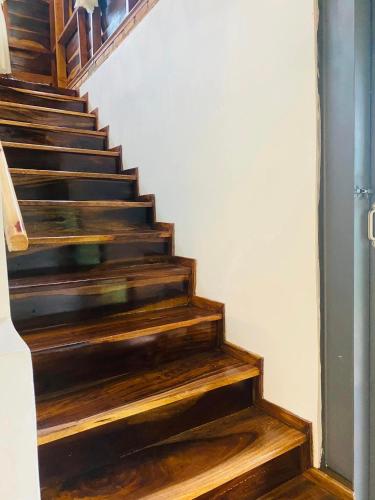 a stairway with wooden steps in a house at Lam Nguyên Charming House in Bao Loc