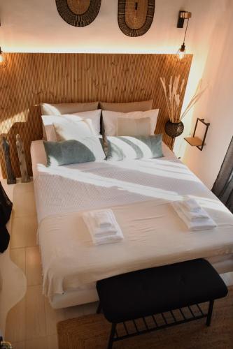 a bedroom with a large bed with white sheets and pillows at NISOS Home Stay in Mýkonos City