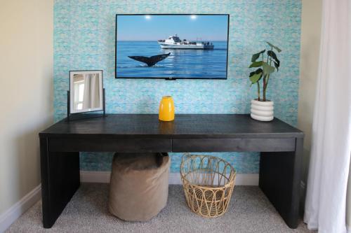 a black desk in a room with a picture of a boat at Luxury Beach Home - Steps to the Sand, Game Room, Firepit, Deck in Oxnard